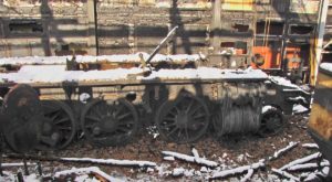 Nach dem Brand in der BDB-Werkstätte in Interlaken ist der Rahmen der C5/6 2969 mit Schnee und Bruchstücken von Dachziegeln bedeckt, die Räder rostig vom Löschwasser, 22.11.2013 | Bild: Riccardo Keller